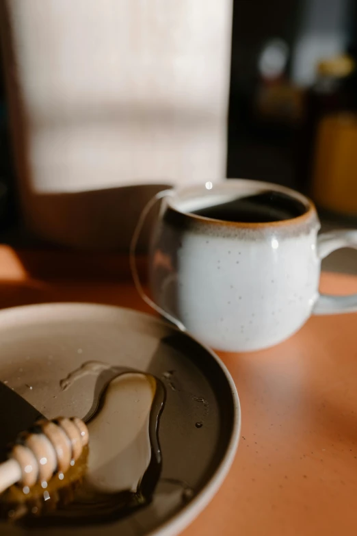 a plate of food sitting on a table next to a cup of coffee, a still life, trending on unsplash, process art, honey dripping, thumbnail, handmade pottery, middle close up shot