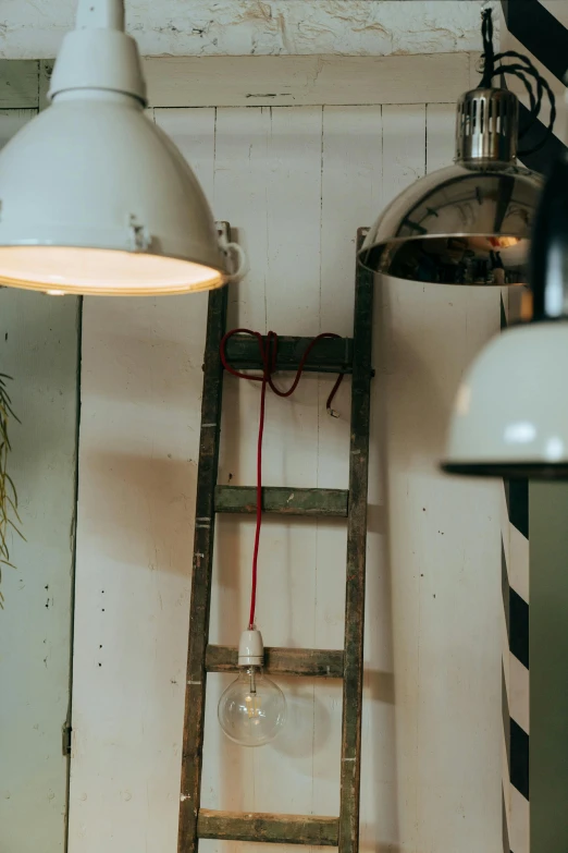 a ladder leaning against a wall next to a lamp, by Jan Tengnagel, trending on pexels, retro lights, dwell, upcycled, cafe lighting