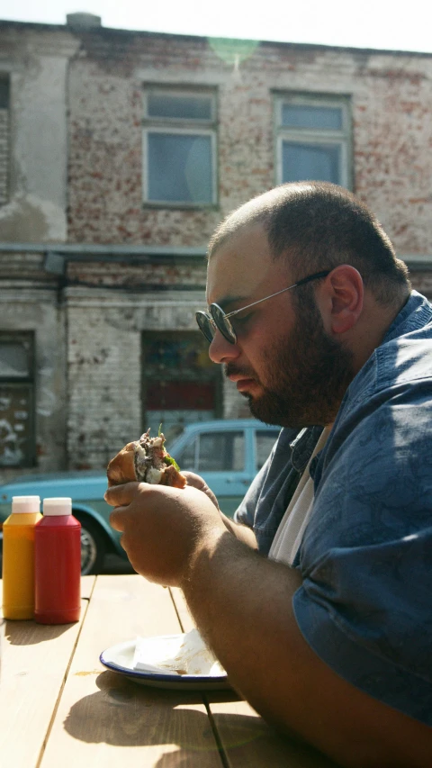 a man sitting at a table eating a sandwich, pexels contest winner, photorealism, action bronson, square, ukrainian, shot from movie