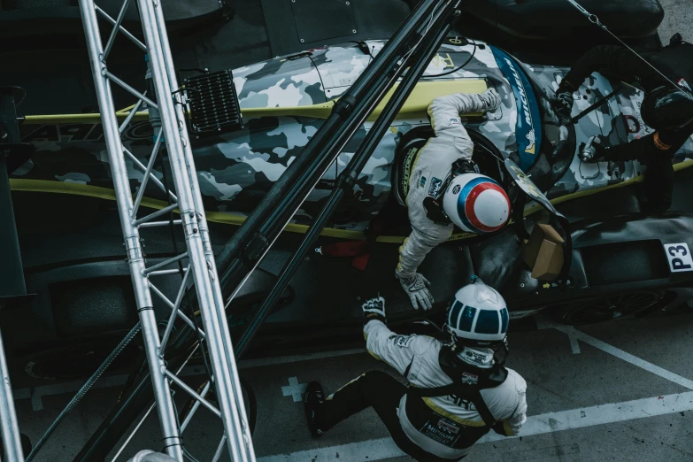 a man that is standing in front of a helicopter, at circuit de spa francorchamps, shot from above, two exhausted, lee madgwick & liam wong