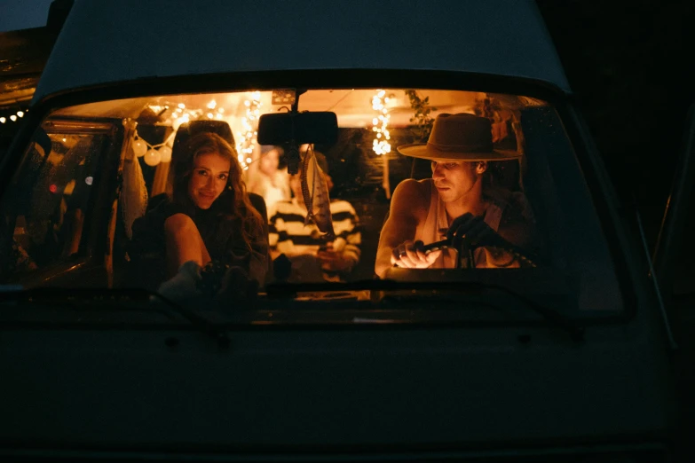 a couple of people sitting in the back of a van, by Lee Loughridge, unsplash contest winner, lit up, film, alana fletcher, miranda meeks