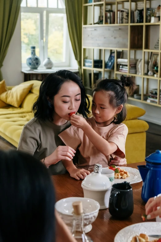 a group of people sitting around a table eating food, young asian girl, families playing, wētā fx, profile image