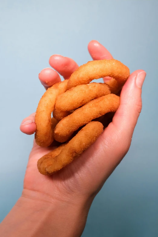 a person holding a bunch of doughnuts in their hands, inspired by Ronald Rae, very long fingernails, square, extra crisp image, up-close