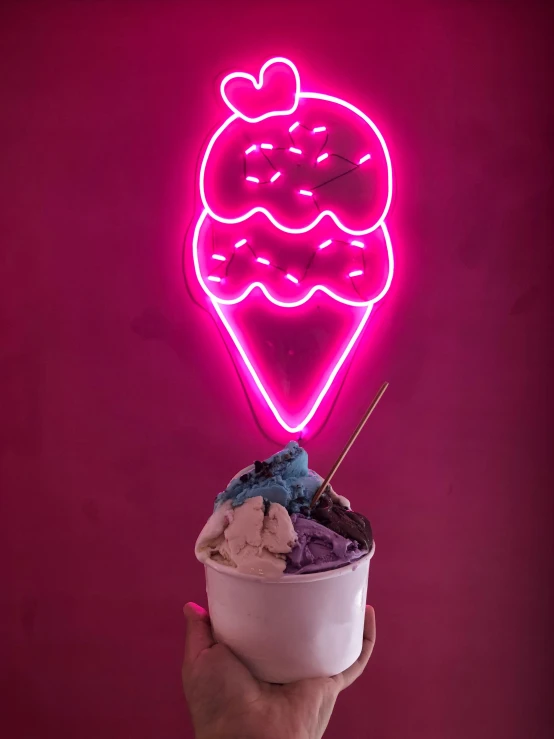 a person holding a cup of ice cream in front of a neon sign, profile image
