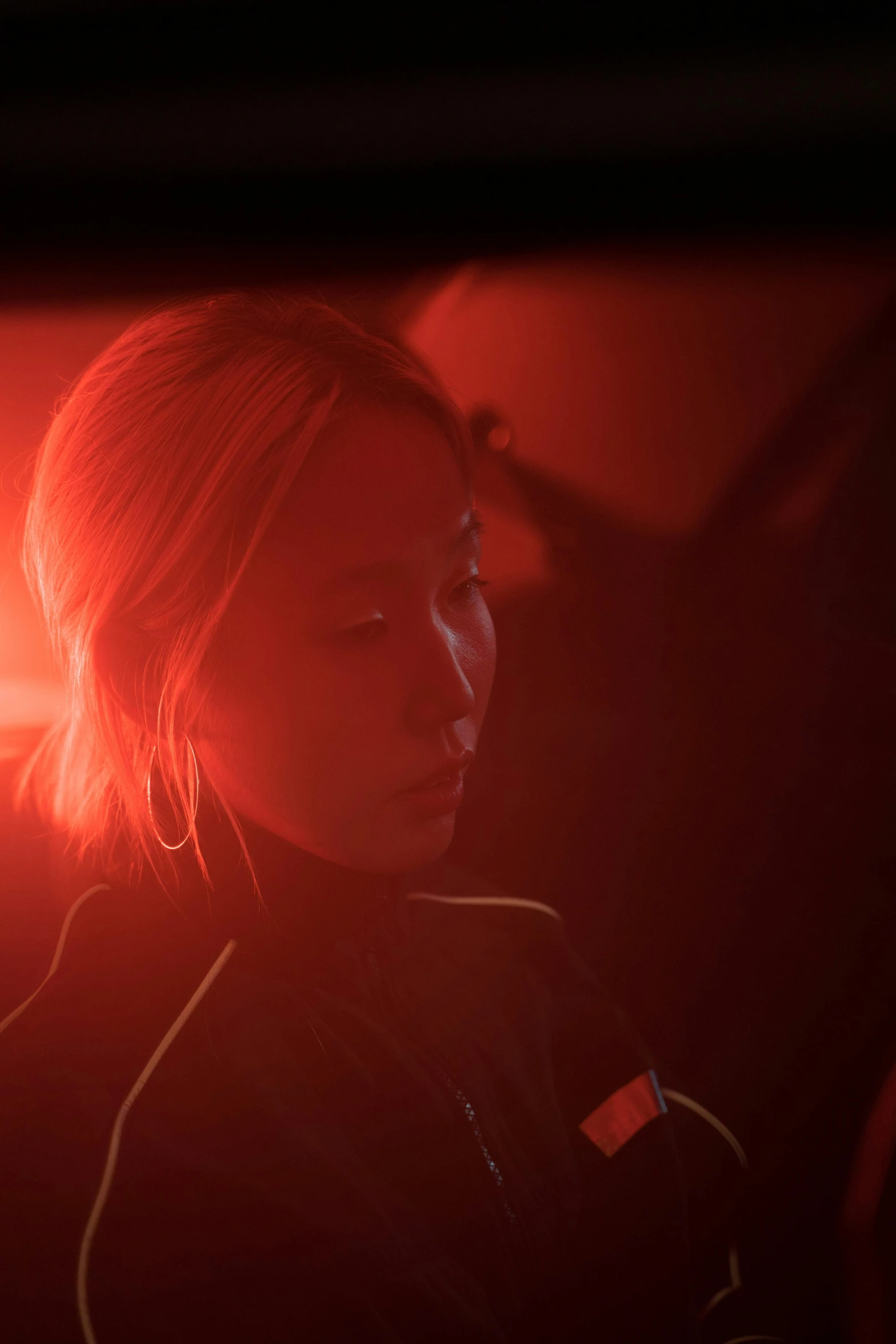 a woman sitting in the passenger seat of a car, inspired by roger deakins, yang qi, detailed red lighting, on a space station, performance