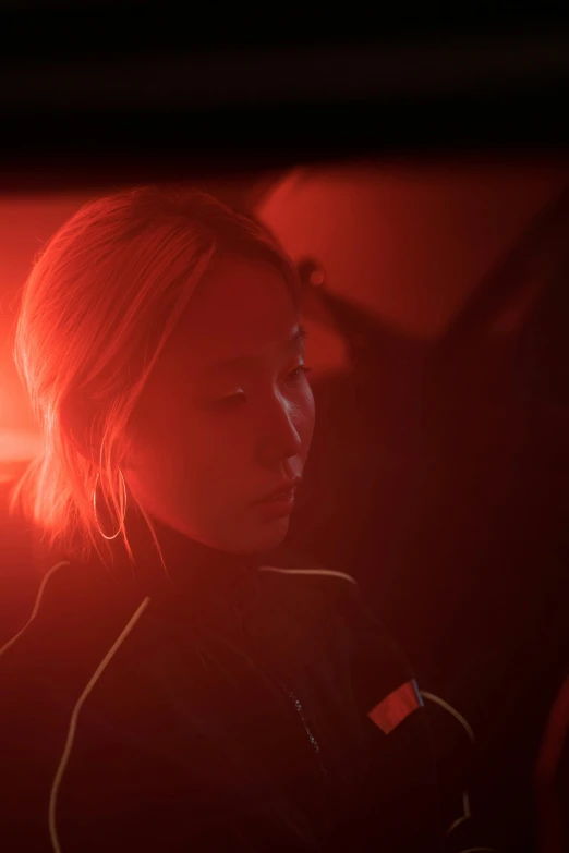 a woman sitting in the passenger seat of a car, inspired by roger deakins, yang qi, detailed red lighting, on a space station, performance