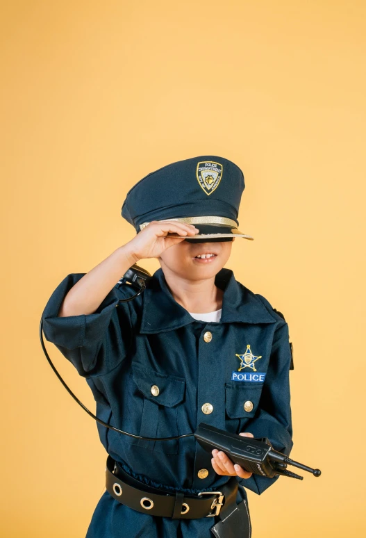 a woman in a police uniform holding a gun, by Alison Geissler, trending on pexels, pop art, little kid, costume, boys, 🚿🗝📝