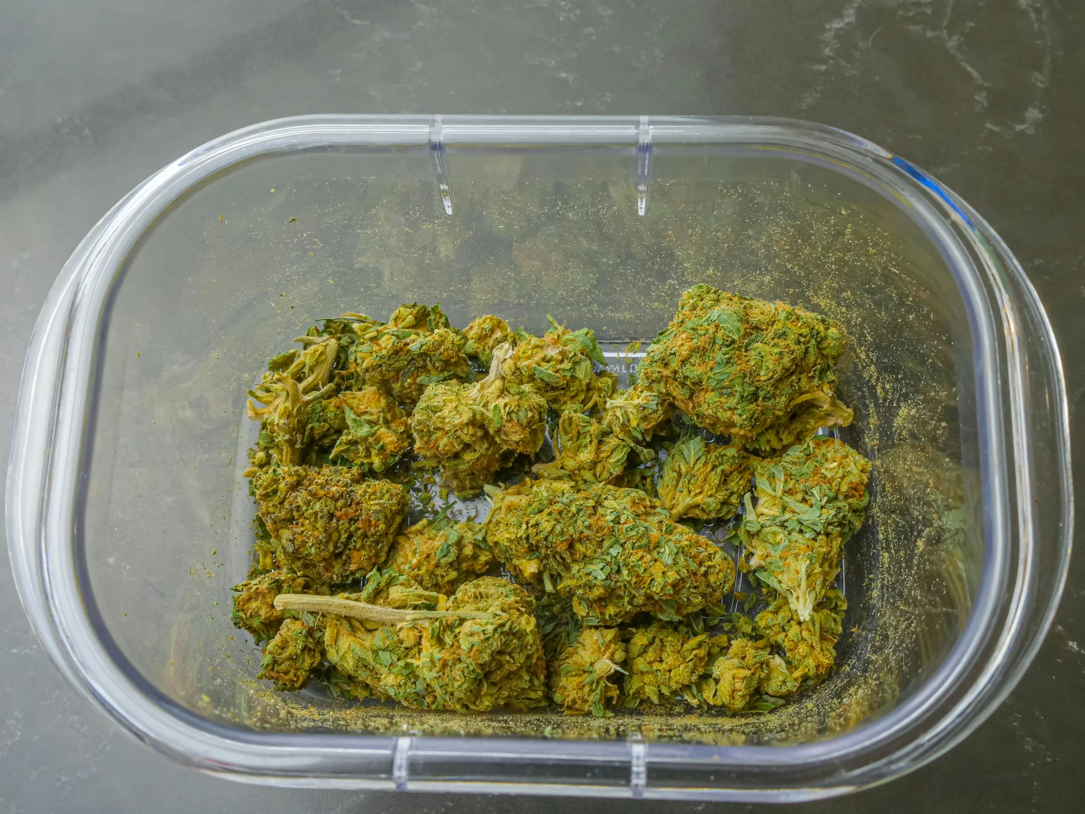 a container filled with marijuana buds sitting on top of a table, process art, serving suggestion, lush greens, high angle shot, high quality product image”