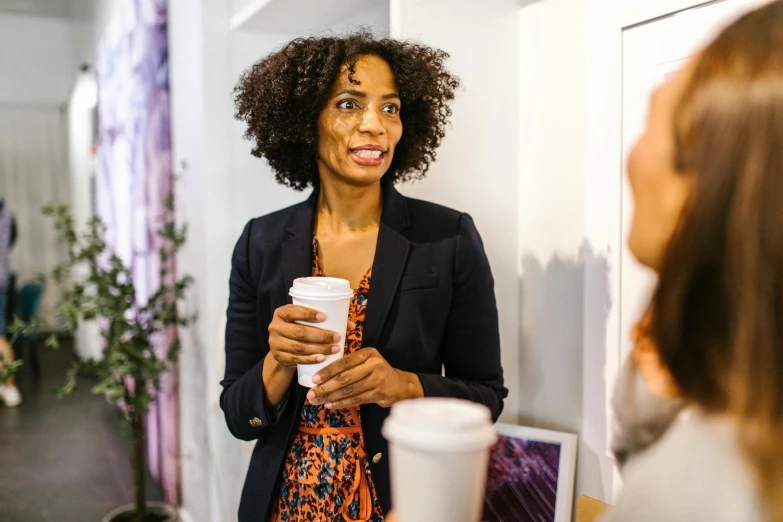 a woman standing in front of a mirror holding a cup of coffee, networking, aida muluneh, profile image, multiple stories