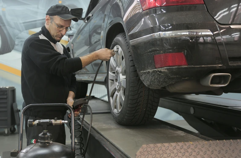 a man working on a car in a garage, pexels contest winner, les automatistes, 15081959 21121991 01012000 4k, highly detailed wheels, in style of ultra realistic, hoses