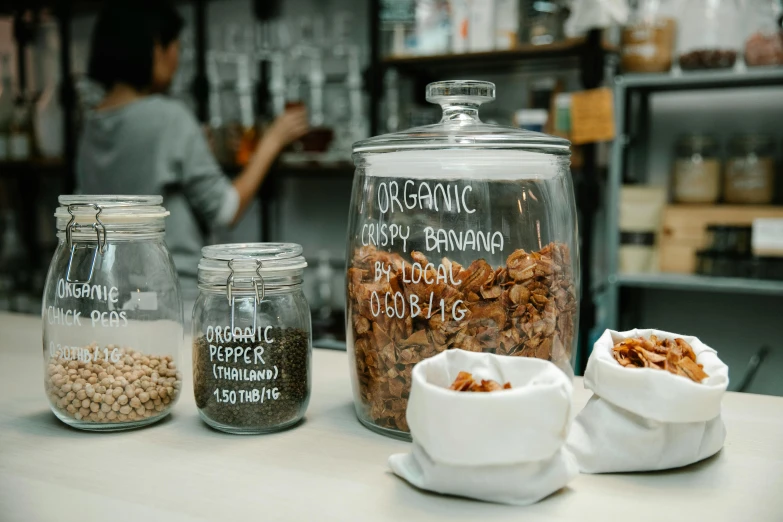 a couple of jars sitting on top of a counter, by Emma Andijewska, trending on unsplash, organic biomass, aussie baristas, seeds, malaysian