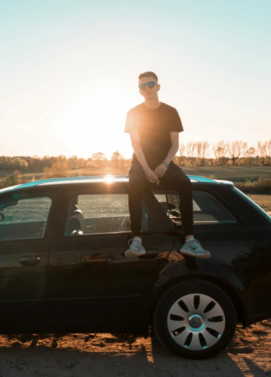 a man standing on top of a black car, pexels contest winner, bad bunny, sun behind him, avatar image, fullbody photo