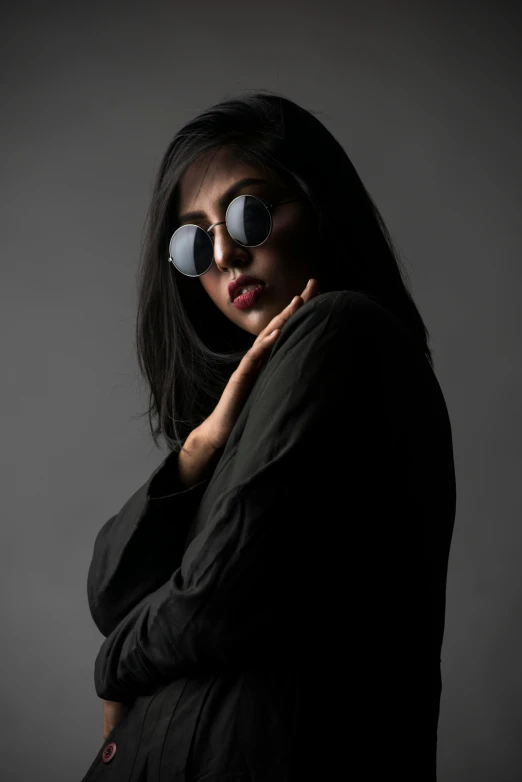 a woman with a pair of glasses on her face, by Sven Erixson, pexels contest winner, minimalism, dark minimal outfit, faridah malik, cool pose, round sunglasses