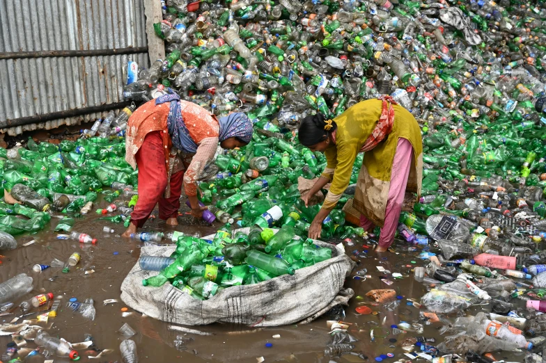 a couple of women standing next to a pile of bottles, plasticien, avatar image, bangladesh, thumbnail, flattened