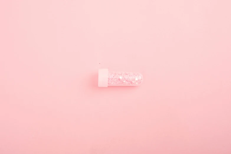 a pink pill sitting on top of a pink surface, by Attila Meszlenyi, trending on pexels, conceptual art, glitter gif, water pipe, ffffound, paper