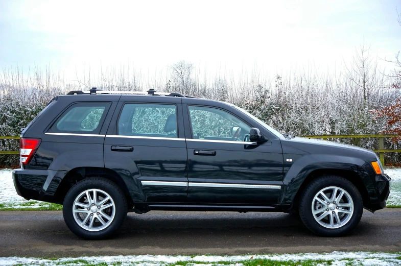 a black jeep parked on the side of a road, by Andries Stock, shiny silver, 2263539546], vehicle profile, inside a grand