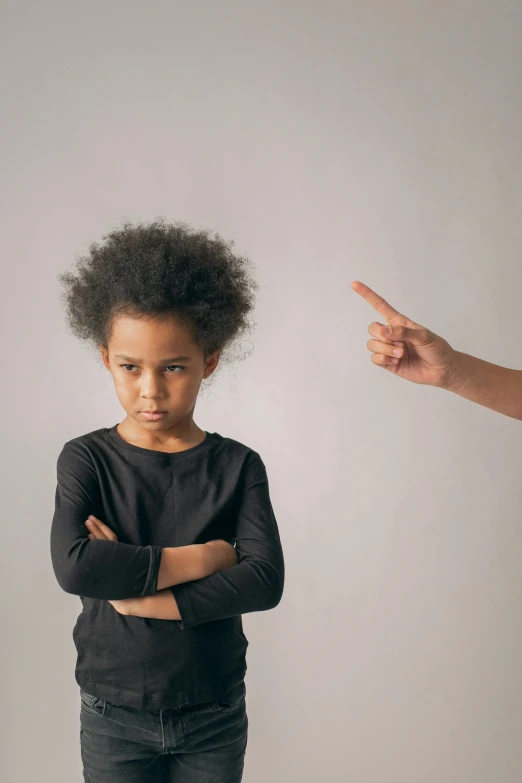 a little boy standing in front of an adult pointing at him, incoherents, photo of a black woman, bullying, downward gaze, girl standing