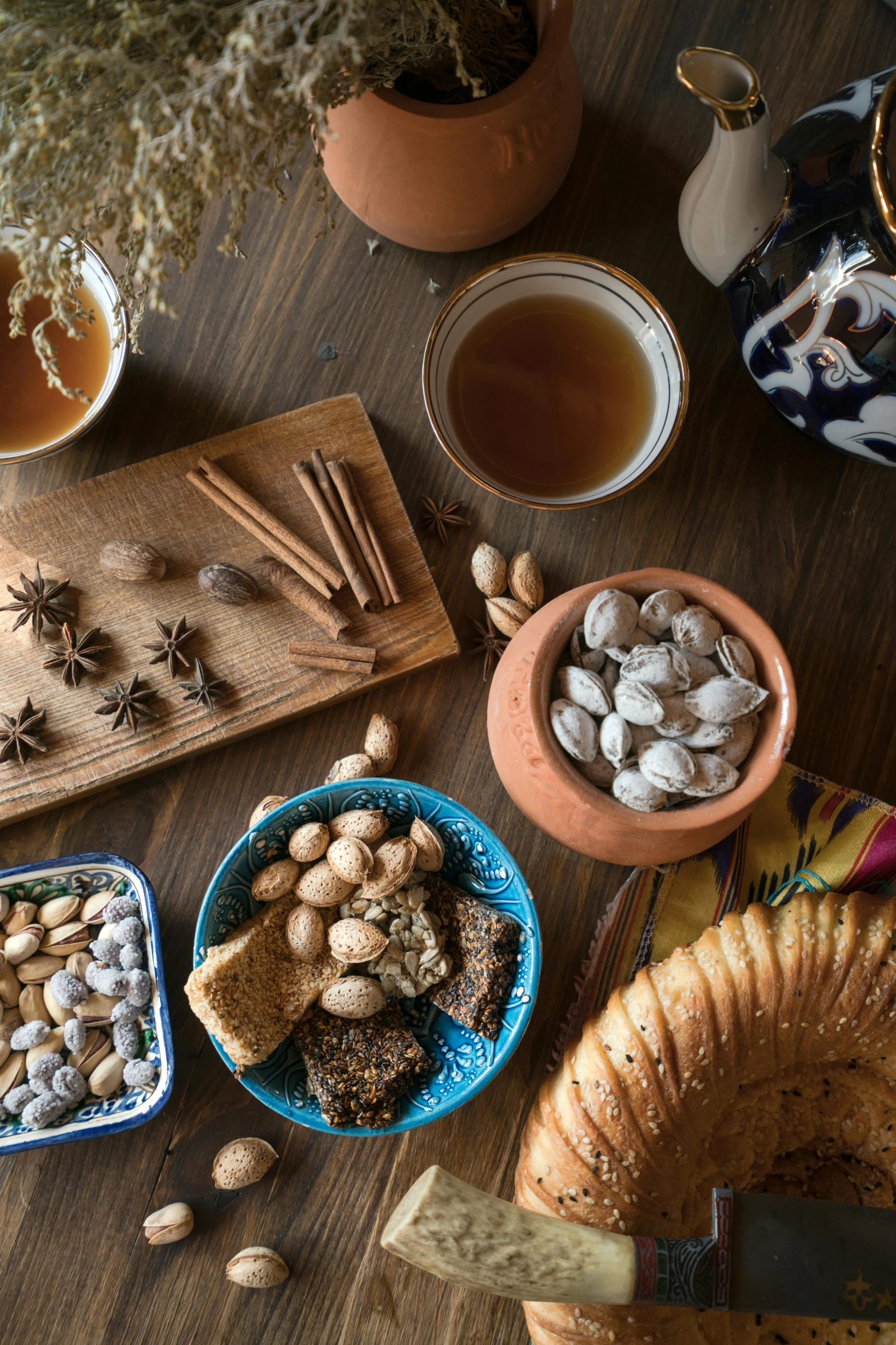 a wooden table topped with plates of food, a still life, trending on pexels, moroccan tea set, nut, thumbnail, square