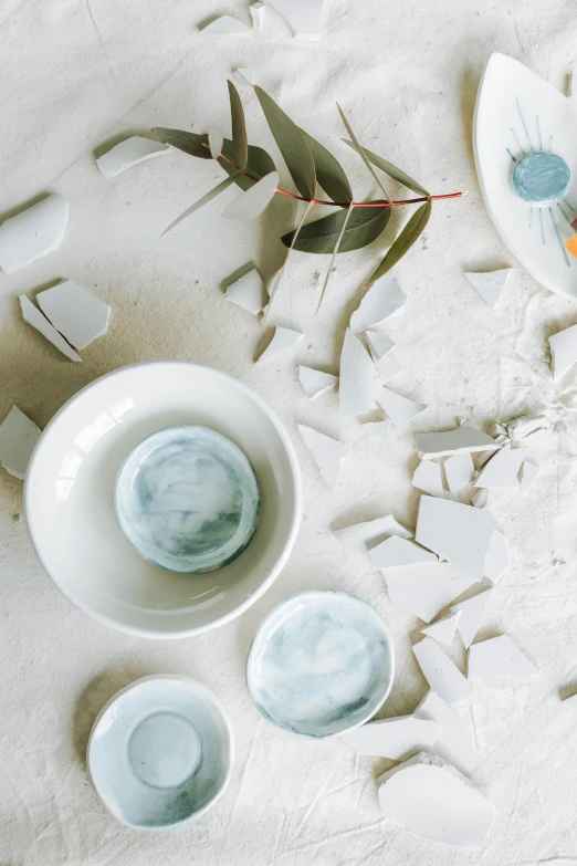 a close up of a plate of food on a table, a still life, inspired by Kim Tschang Yeul, trending on unsplash, process art, broken tiles, white and pale blue, cups and balls, shattering