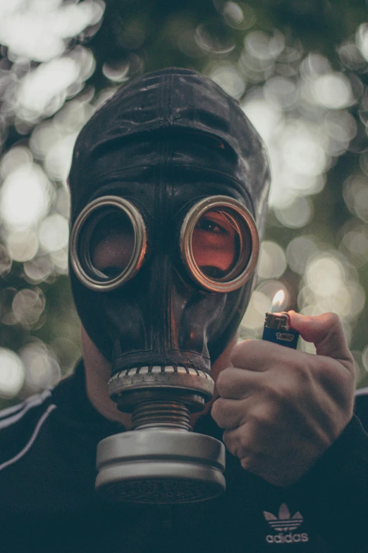 a man in a gas mask holding a lighter, pexels contest winner, instagram post, biological photo, hand over mouth, profile image