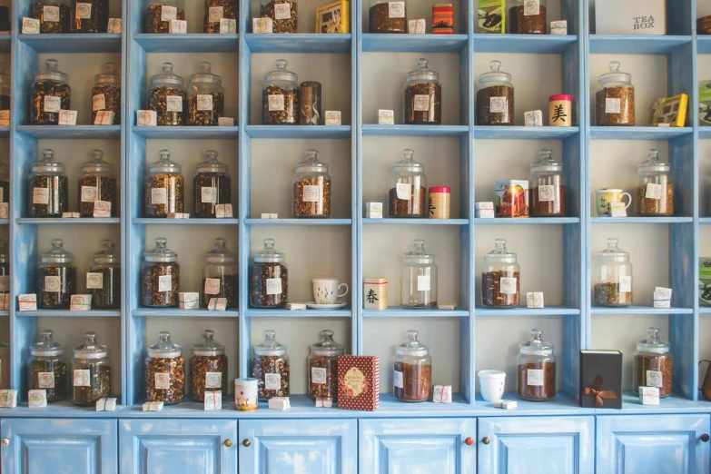 a bunch of jars that are on a shelf, pexels, secret tea society, amber and blue color scheme, thumbnail, cabinets