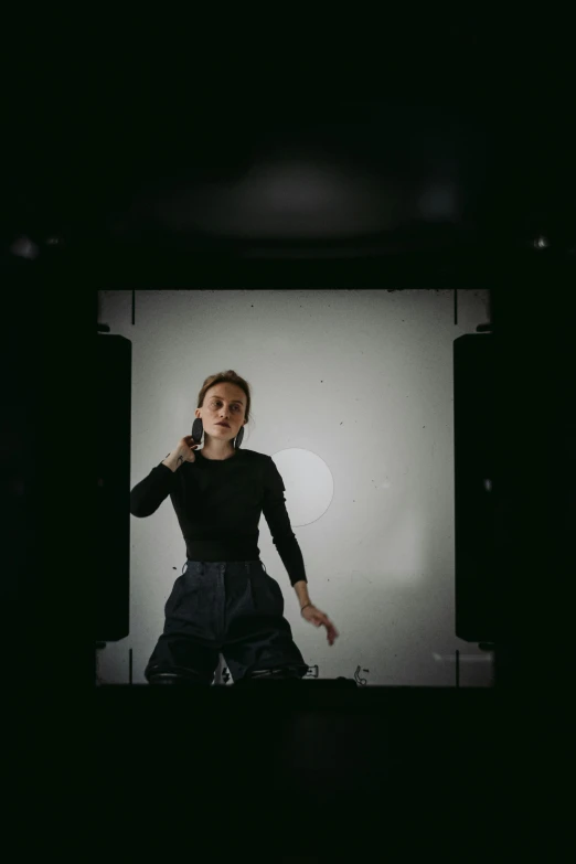 a woman standing in front of a white screen, a hologram, inspired by Anna Füssli, unsplash, studio medium format photograph, film still of emma watson, action pose, dark photo