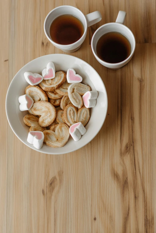 a bowl of cookies and two cups of tea on a table, pexels contest winner, dau-al-set, bunnies, marshmallow, on wooden table, back