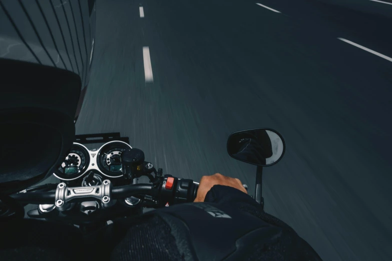 a person riding a motorcycle down a highway, trending on unsplash, calm night. over shoulder shot, cruise control, plain background, high angle close up shot