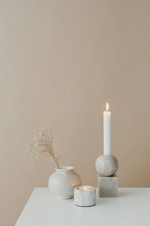 a couple of white vases sitting on top of a table, by Anna Boch, trending on pexels, minimalism, holding a candle, soft colors, studio photoshot, limestone