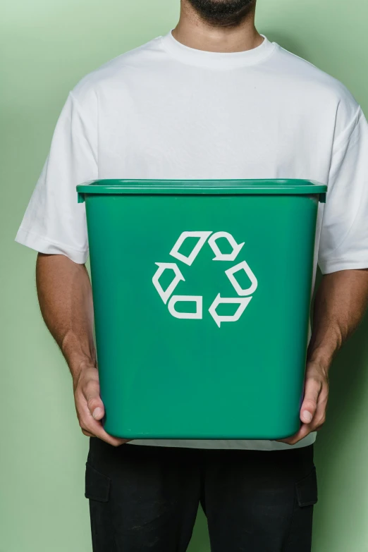 a man holding a green recycling bin in his hands, by Everett Warner, pexels, plasticien, made of cardboard, color corrected, no - text no - logo, green and white