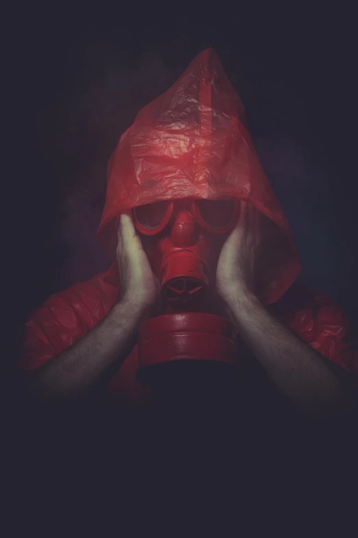 a man in a red hood covering his face with his hands, an album cover, by Adam Marczyński, pexels contest winner, respirator, chemicals, looking sad, scp-049
