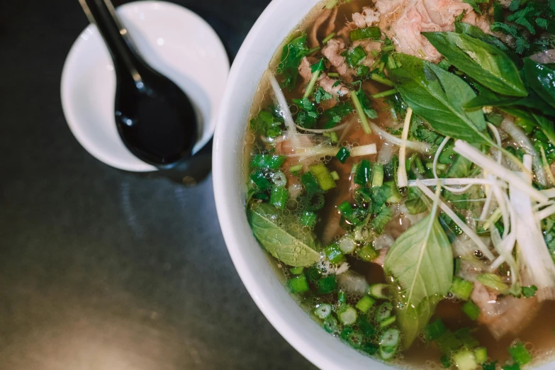 a bowl of soup sitting on top of a table, inspired by Tan Ting-pho, trending on unsplash, fan favorite, square, san francisco, drinking