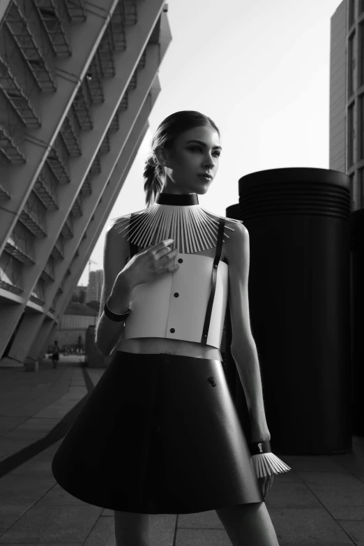 a woman standing in front of a tall building, inspired by Peter Lindbergh, tumblr, hypermodernism, wearing a cropped top, monochrome 3 d model, “zendaya, editorial footage