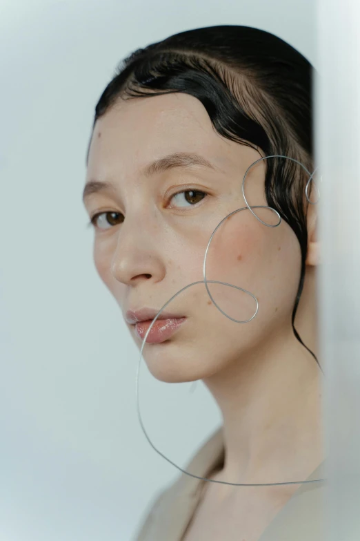 a woman that is standing in front of a mirror, an album cover, inspired by Gao Cen, trending on pexels, featuring rhodium wires, close up portrait photo, bubbling skin, showstudio