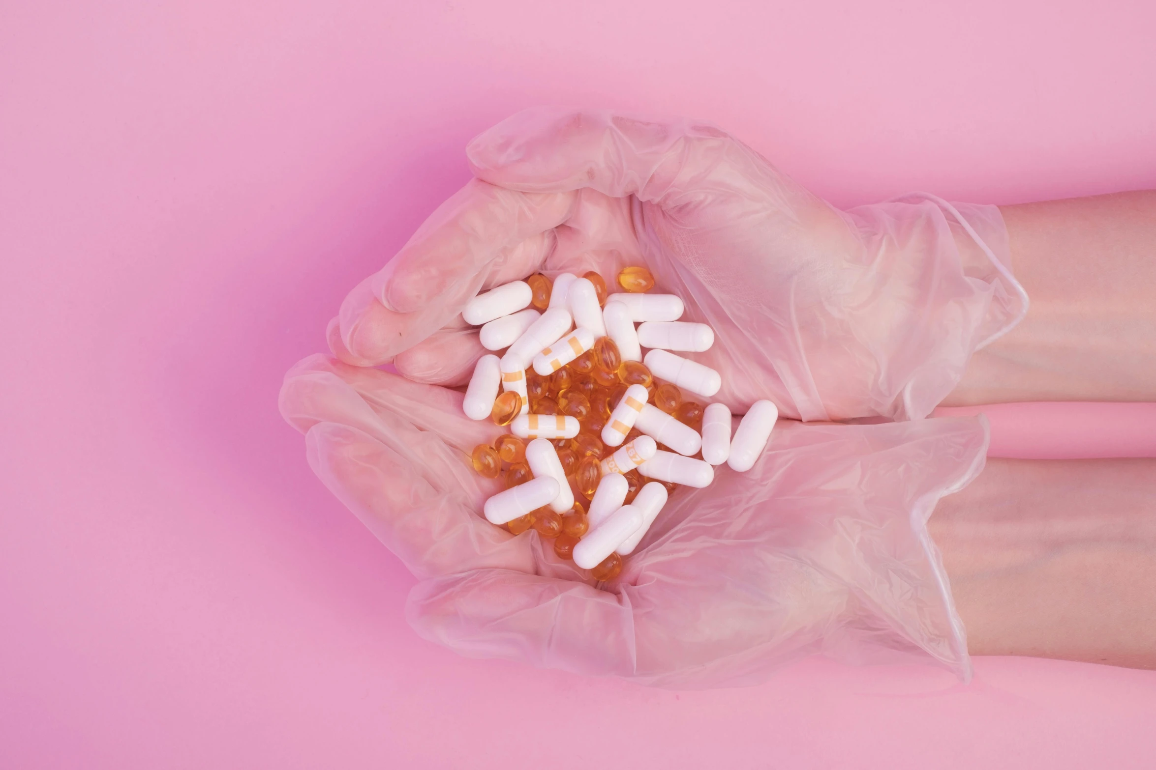 a person holding a handful of pills in their hands, an album cover, by Julia Pishtar, trending on pexels, toned orange and pastel pink, made of lab tissue, about to consume you, made of liquid