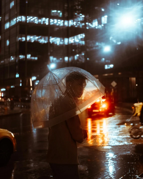 a person standing in the rain with an umbrella, inspired by Elsa Bleda, lgbtq, street lanterns are shining, snapchat photo, in the middle of the city