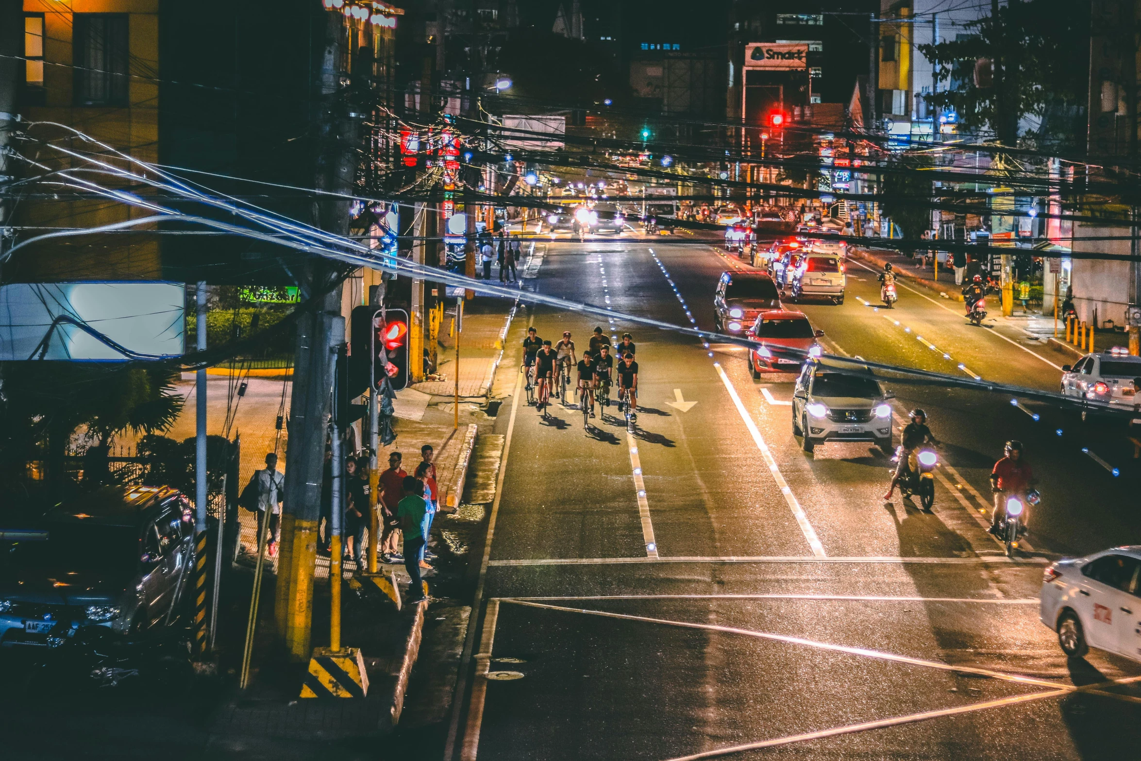 a city street filled with lots of traffic at night, pexels contest winner, 1970s philippines, thumbnail, people walking in the distance, running lights