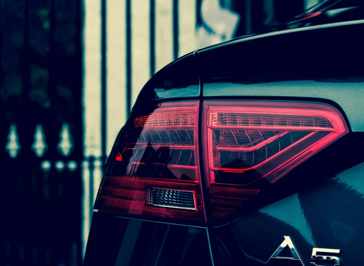 a close up of the tail lights of a car, pexels contest winner, aestheticism, style of flavie audi, filtered evening light, black car, colorful”