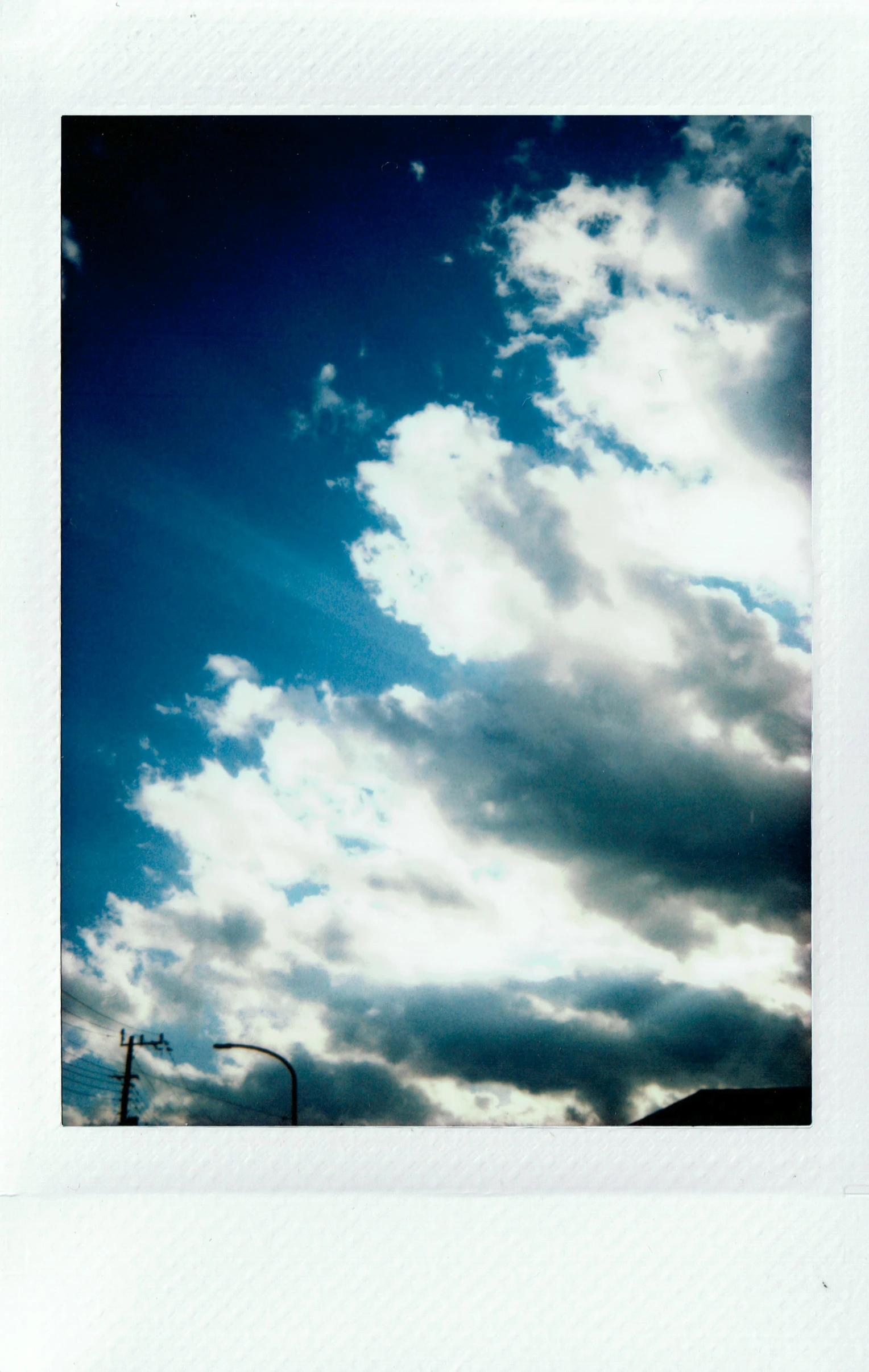 a polaroid picture of a blue sky with clouds, a polaroid photo, by Nathalie Rattner, postminimalism, streetlight, hot summer sun, taken on a 2010s camera, :: morning