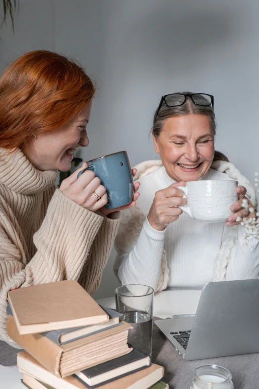 two women sitting at a table with a laptop and a cup of coffee, by Jan Tengnagel, trending on pexels, renaissance, laughter, motherly, avatar image, winter