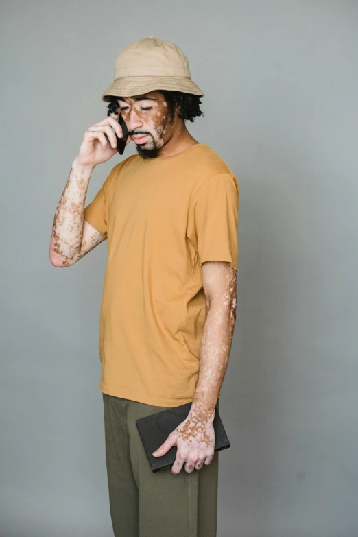 a man in a hat talking on a cell phone, by Miyamoto, trending on unsplash, renaissance, dirty short sleeved shirt, ocher, large tall, no - text no - logo