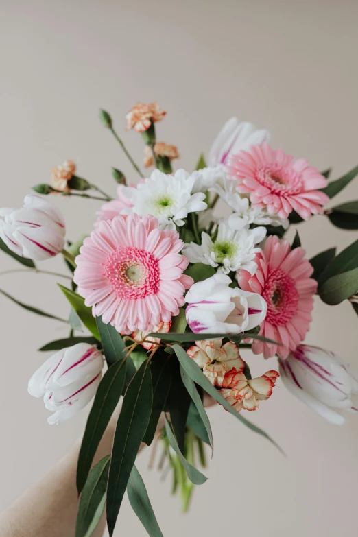 a person holding a bouquet of pink and white flowers, a still life, pexels contest winner, lighthearted celebration, crisp detail, daisies, delicate patterned