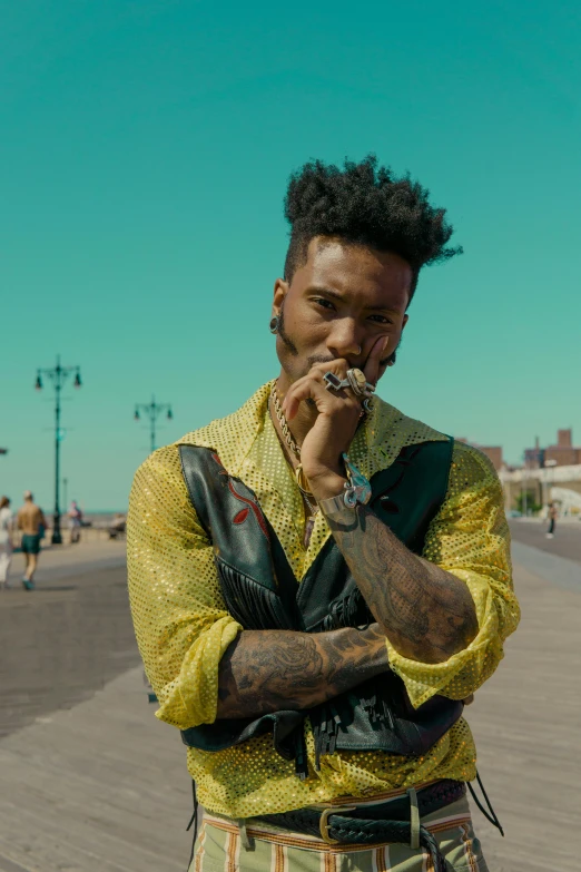 a man standing on a boardwalk smoking a cigarette, an album cover, trending on pexels, playboi carti, still frame from a movie, pompadour, patterned clothing