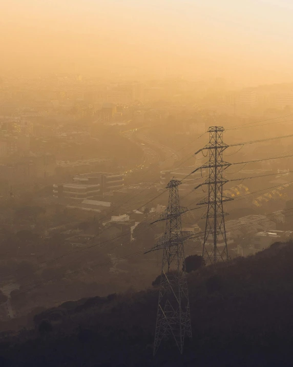 a view of a city from the top of a hill, inspired by Elsa Bleda, powerlines, during sandstorm, pollution, instagram post