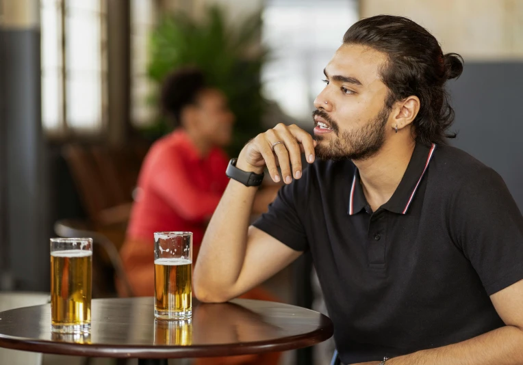 a man sitting at a table with a glass of beer, taking a smoke break, mental health, manly, looking distracted and awkward