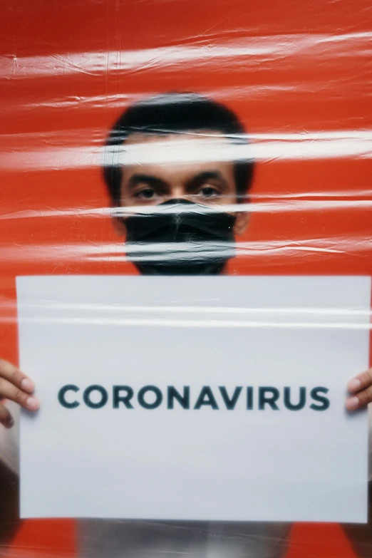 a man holding a sign that says coronavirus, an album cover, shutterstock, pareidolia, dark. no text, ap press photo, healthcare