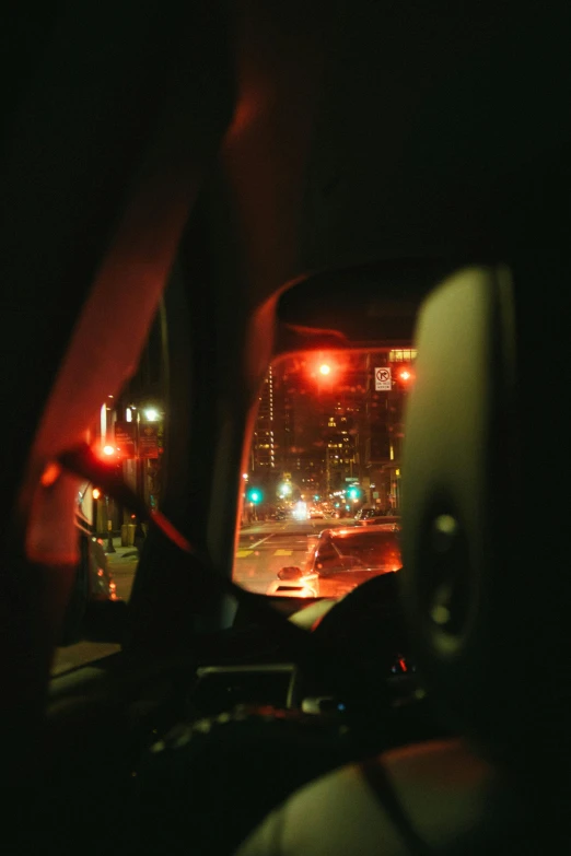 a view of a city at night from inside a car, inspired by Nan Goldin, unsplash contest winner, realism, todd hido, taken in the late 2010s, red light, downtown