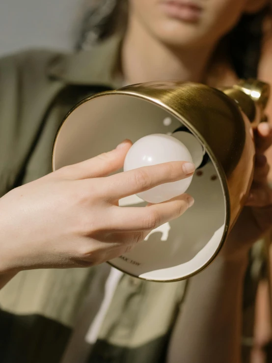 a close up of a person holding a cup, lamp ( ( ( mirror ) ) ) ), marble and hint gold, highly capsuled, light mode