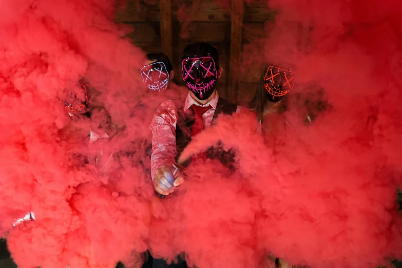 a group of people with red smoke in their hands, an album cover, pexels contest winner, anonymous mask, colored lasers, red suit, smoke filled room