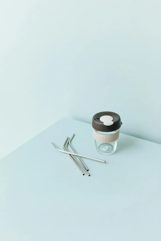 a cup of coffee sitting on top of a table, a still life, by karlkka, minimalism, with a straw, stainless steel, high quality product photo, seaglass